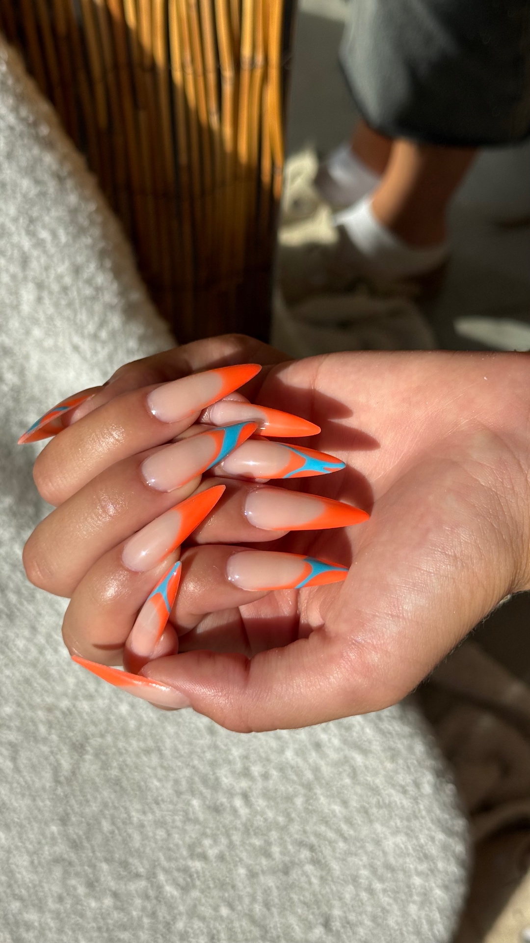 Ongles stiletto french orange avec nail art bleu